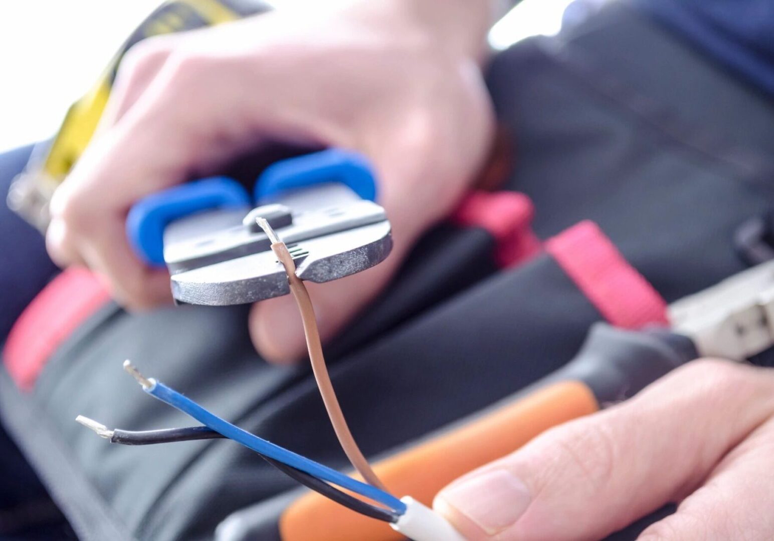 A person is holding some wires and a pair of scissors