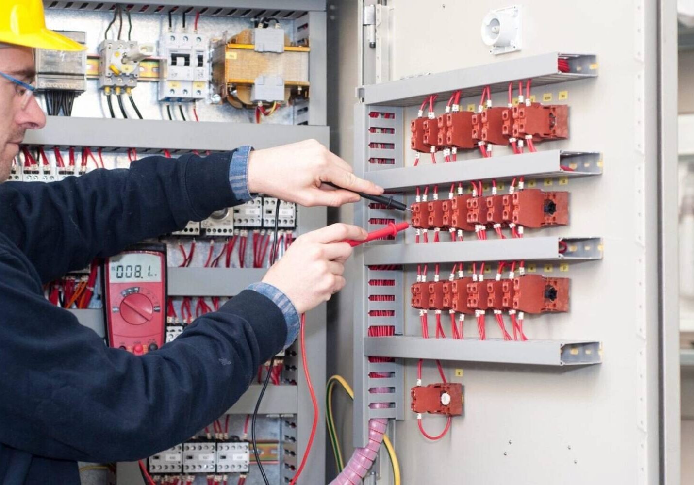 A person is working on an electrical panel.